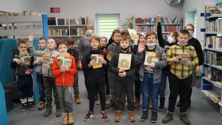 W bibliotece stoi grupa dzieci z klasy 4. Wszyscy trzymają w ręku nagrody.