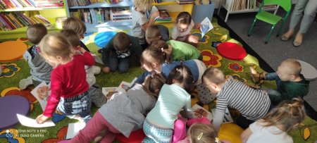 Dzieci na dywanie grupują obrazki bohaterów bajek