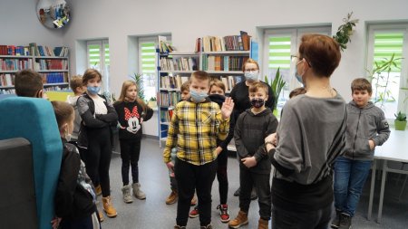 Bibliotekarka opowiada dzieciom o działalności biblioteki