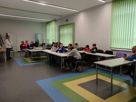 Prowadzące mówią do siedzących w ławkach uczestników