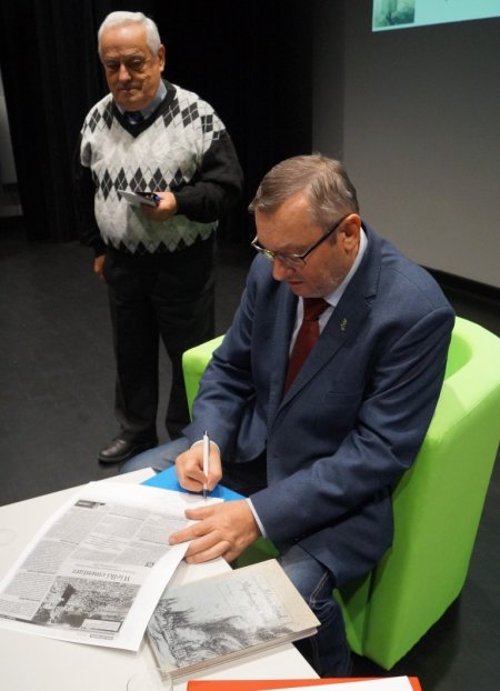 dr Leon Popek podpisuje książkę jednemu z uczestników spotkania