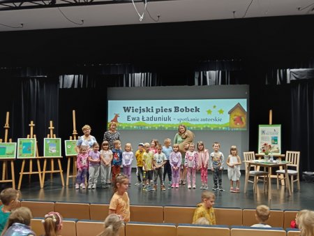 Grupa dzieci z pisarką i posem Bobkiem