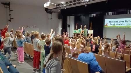 Dzieci na widowni podnoszą rece aby zadać pytanie