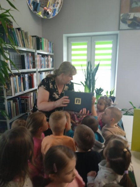 przedszkolaki oglądają ksiązki na półce