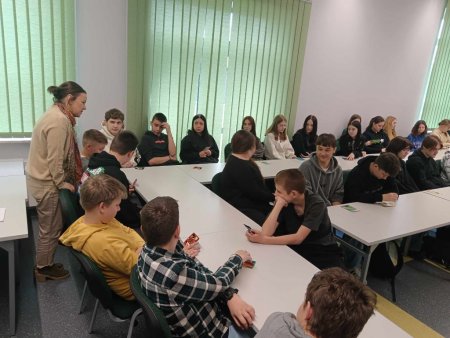 Prowadzące mówią do siedzących w ławkach uczestników