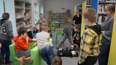 Grupa dzieci pokazuje tytuł książki, zabawa w kalambury