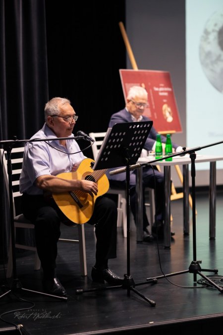 Na scenie jeden z uczestników gra na gitarze i spiewa