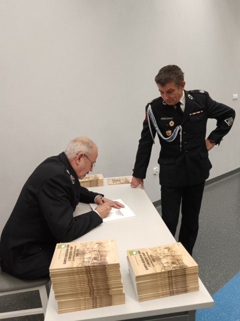Autor rozdaje ksiązki z autografem