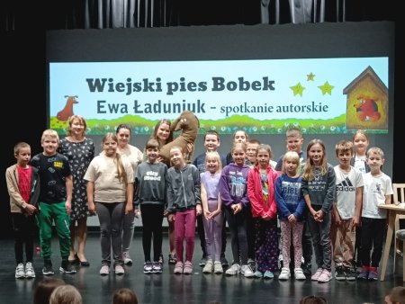 Grupa dzieci z pisarką i posem Bobkiem