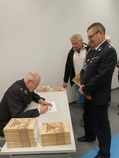 Autor rozdaje ksiazki z dedykacja