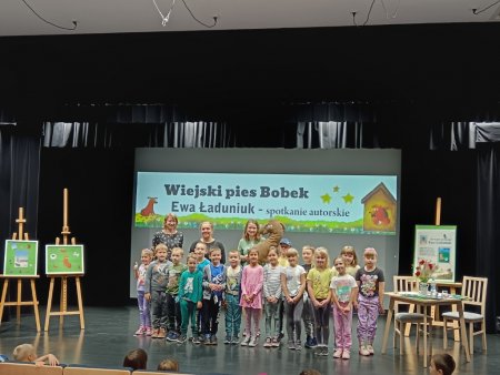 Grupa dzieci z pisarką i posem Bobkiem