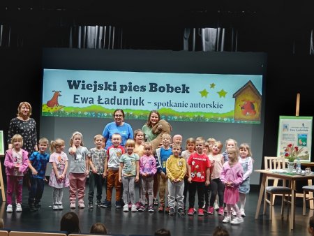Grupa dzieci z pisarką i posem Bobkiem