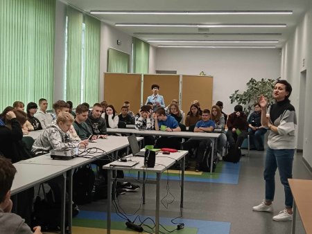 Prowadzące mówią do siedzących w ławkach uczestników
