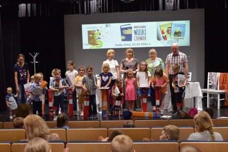 Dyrektorzy szkoły, biblioteki i przedszkola rozdają nagrody dzieciom