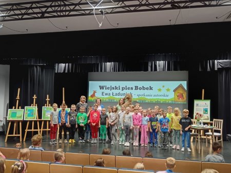 Grupa dzieci z pisarką i posem Bobkiem