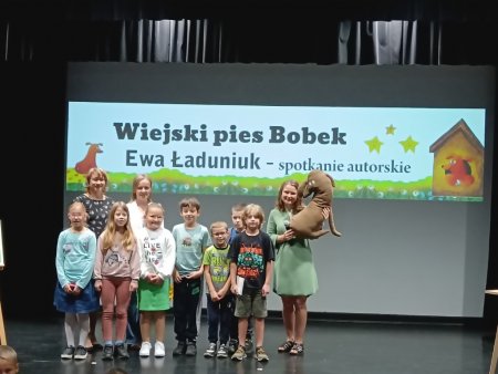Grupa dzieci z pisarką i posem Bobkiem