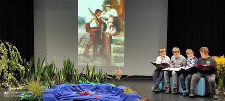 Na scenie dzieci ze szkoły czytają Powrót taty , w tle wystrój jeziora i lasu